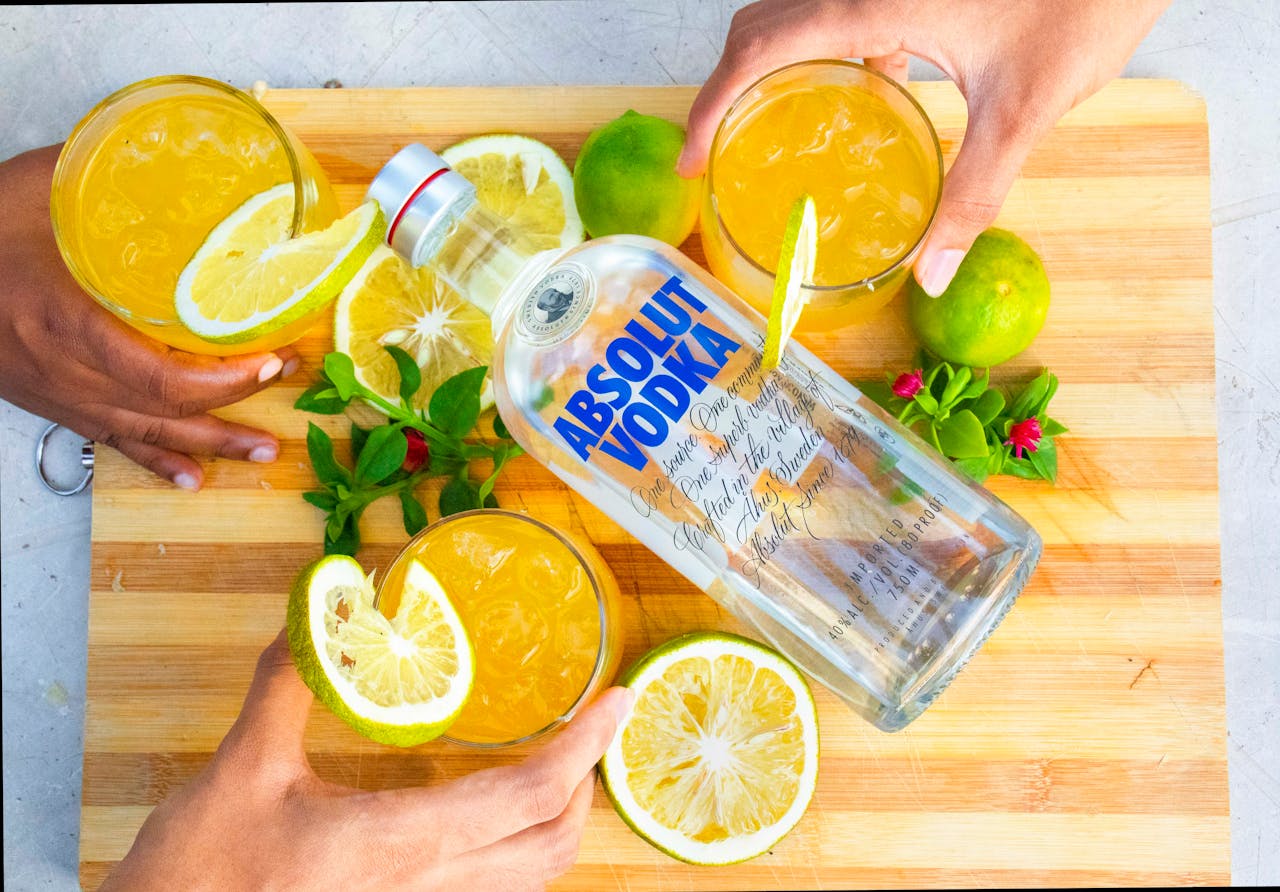 A top view of a vibrant cocktail setup featuring Absolut Vodka and citrus garnishes.