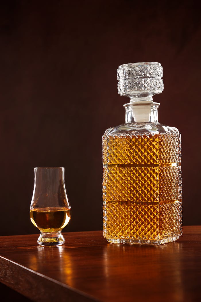 Crystal whiskey decanter and glass on a wooden table, perfect for refined drinking moments.