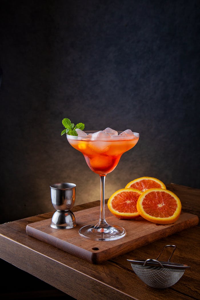 Elegant cocktail with orange slices on a wooden board, perfect for parties.